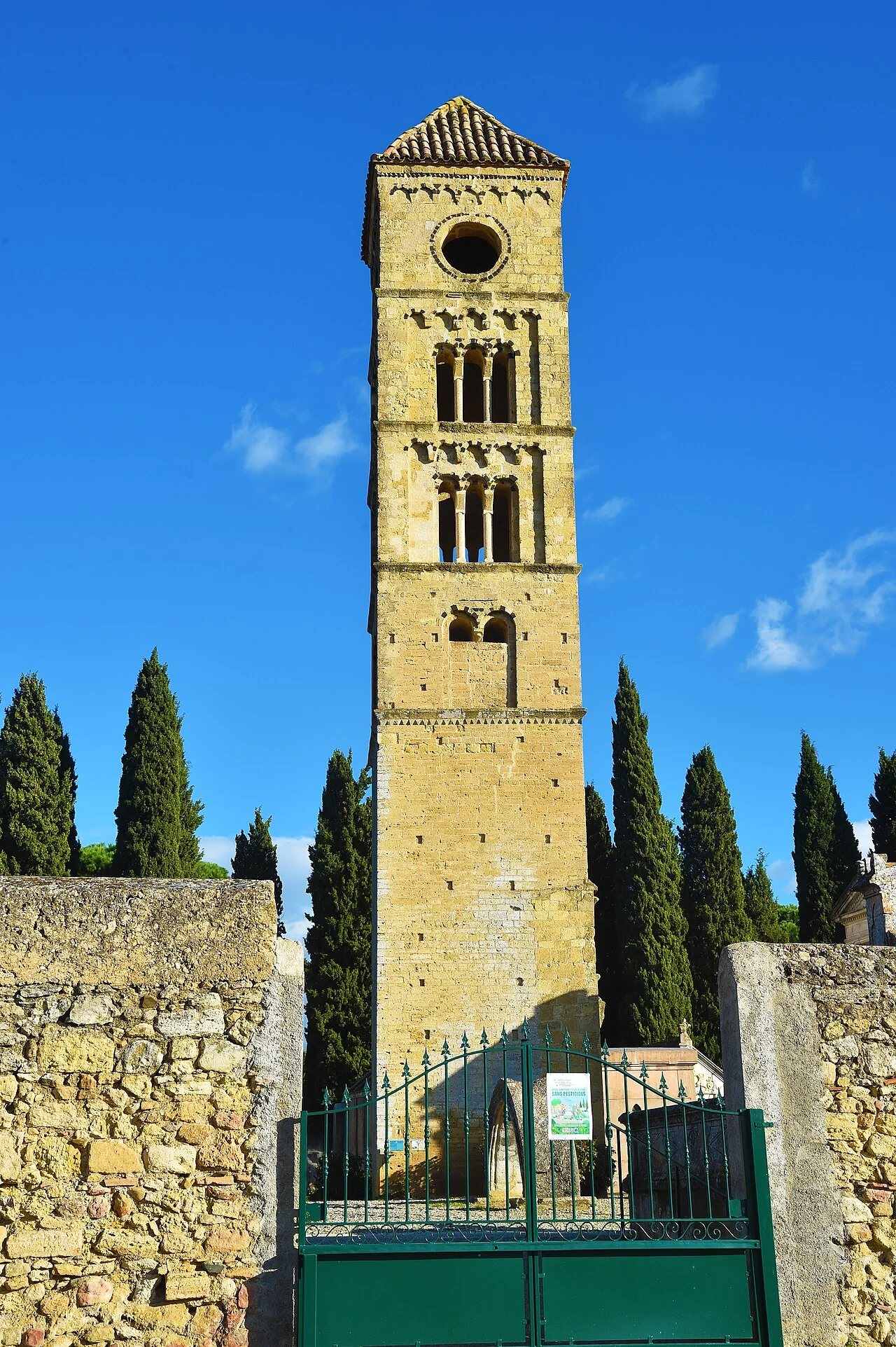 Repli commune Puissalicon (pas une photo du domaine) — la tour romane (clocher médiéval) de Puissalicon, monument emblématique du village, encadrée de cyprès [CC BY-SA 4.0 · Archives départementales de l'Hérault]